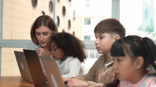 Intelligenter Lehrer, der unterrichtet und Schüler sieht im Klassenzimmer mit Laptop zu. Gelehrsamkeit
.