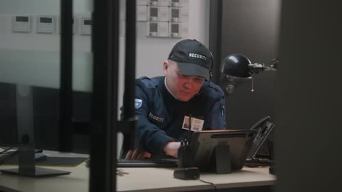 Busy Security Officer Looks View From Security Camera