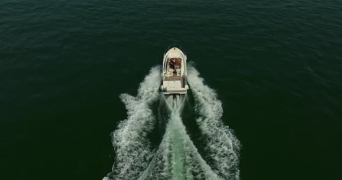 White Luxury Boat Sailing on Clean Blue Sea surfaceAerial View Over Speed Boat with Small Waves in