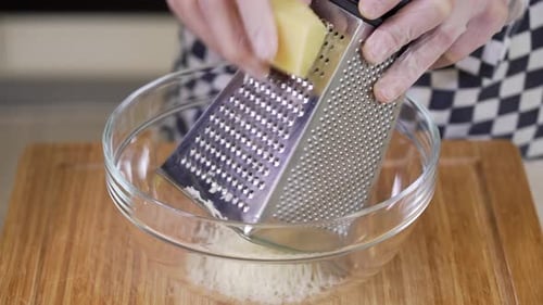 Grating Parmesan Cheese Into a Glass Bowl
