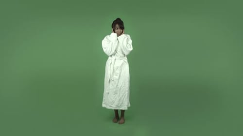 indian woman in bathrobe isolated on green scared screaming