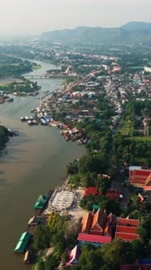 Vertical Aerial fly Kanchanaburi town, Thailand next to kwai River Jungle landscape