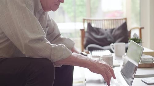 Senior Man Using Laptop Computer Indoors During Daytime