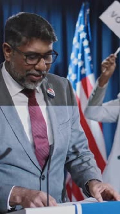 Man Gives Speech at Podium with American Flag