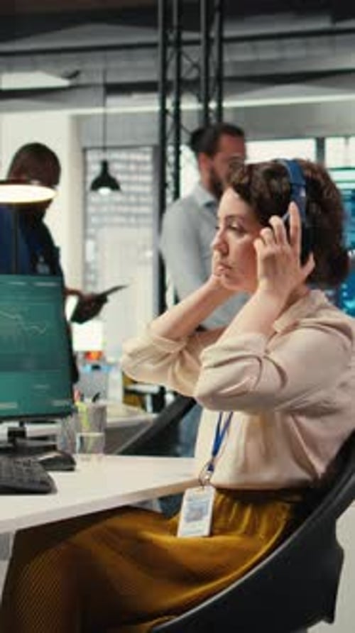 Vertical Video Office Administrator Uses Focus Music on Headset to Solve Tasks