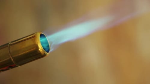 Close-up of a gas torch with a blue flame