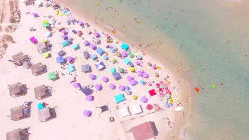 Summertime in a public Beach with colorful umbrellas