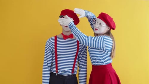 Comedic Mimes Blocking Face Against Yellow Background