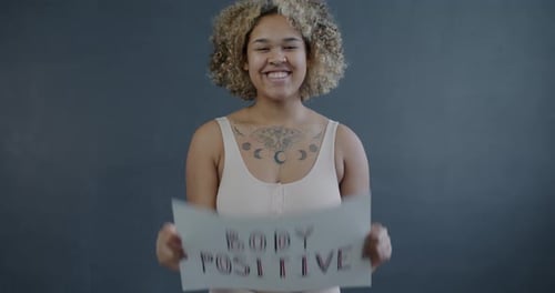 Zeitlupenporträt einer afroamerikanischen Frau in Unterwäsche mit positivem Körperzeichen, die weiterlächelt
