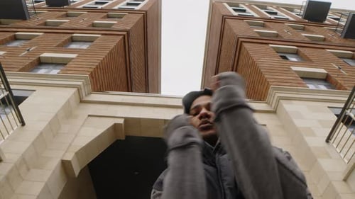 Young Adult Dancing Under Buildings in Urban Environment