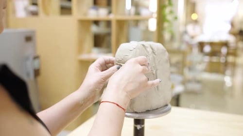 Potter Sculpting Clay Head in Workshop