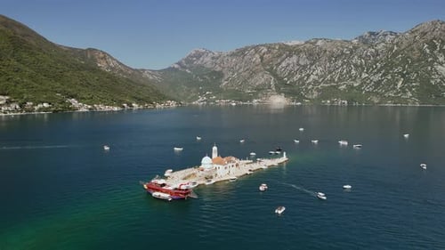Aerial orbits Our Lady of the Rocks artificial island in Montenegro