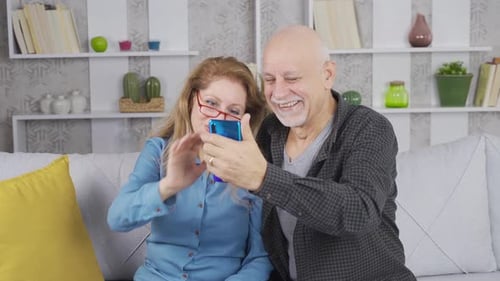 Smiling Couple Video Chatting on Smartphone at Home