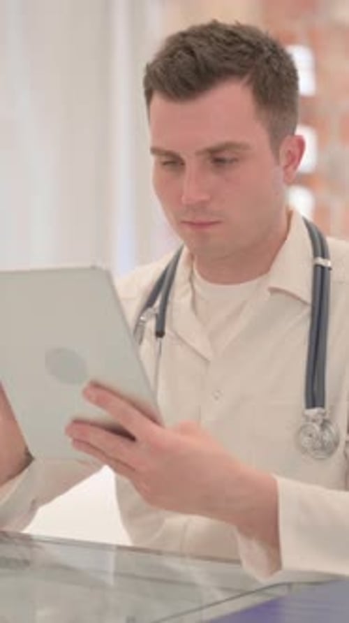 Male Doctor using Tablet in Clinic, Vertical Video