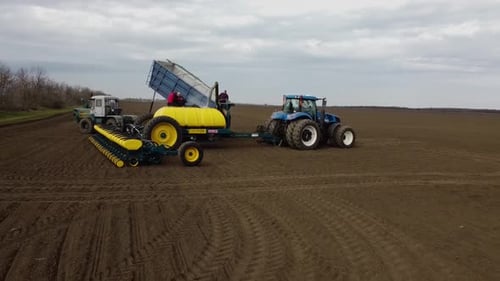 Blue tractor OA working on the field in Ukraine