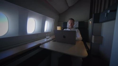 Man Working On Laptop In Airplane First Class
