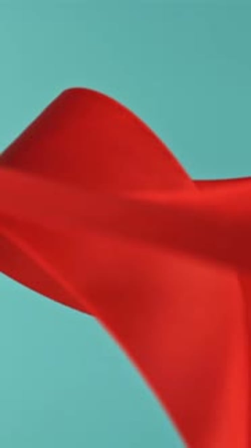A Red Ribbon Flies on a Blue Background Filmed on a Highspeed Camera at 1000 Fps