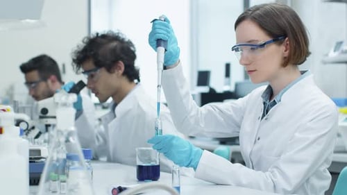 Woman Using Pipette in Bright Science Lab