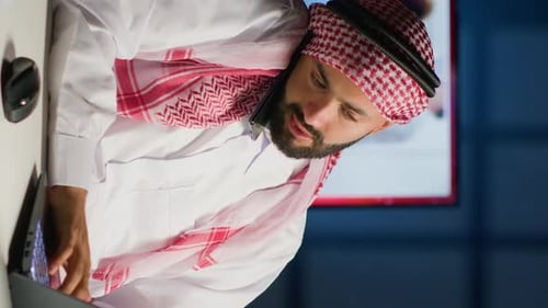 Man Works Late, Answers Phone at Desk