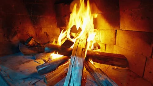 Burning Fireplace Logs Glowing in Brick Interior
