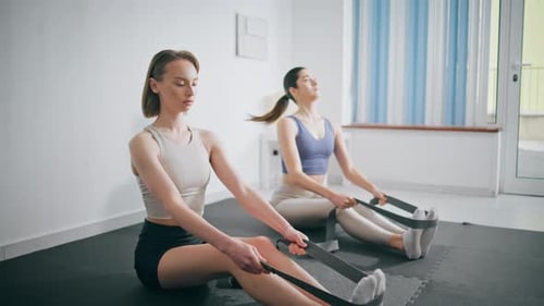 Young Women Exercising Using Resistance Bands