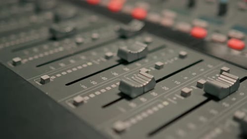 A recording studio control panel mixer with an equalizer faders buttons for a recording of a song