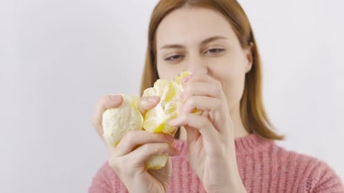 Close-up portrait of woman eating orange. Eat fruit.