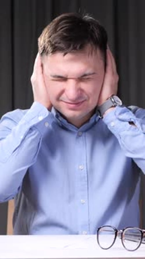 Vertical Video Stressed Office Worker Covering Ears From Noise Pollution