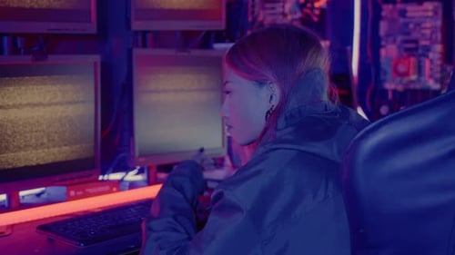 Woman Working at Computer Station with Neon Lighting