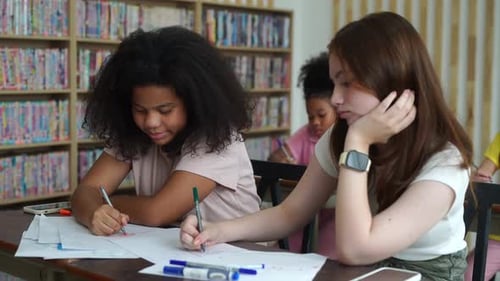Portrait of schoolgirl drawing at the school library