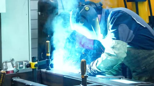 Welder Working with Metal and Bright Sparks