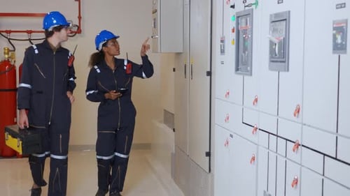 Engineers Inspect Electrical Control Panel in Control Room