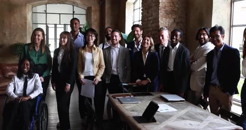 Multiracial business people working inside office while smiling on camera