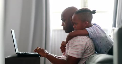 Father and Son Using Laptop Together at Home