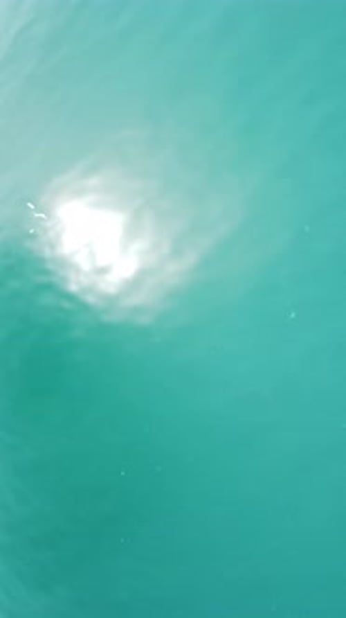 Vertical Aerial View on Sea Water Surface Camera Flies Over Clear Sea Water Sun Glare Abstract