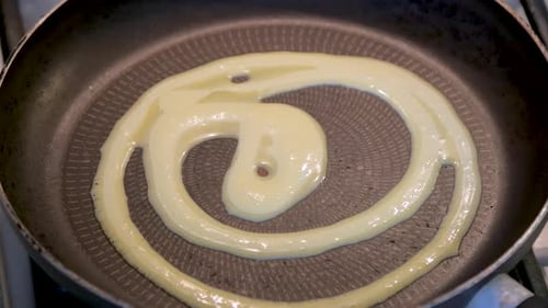 Nahaufnahme einer traditionellen gusseisernen Pfanne, die für den Gebrauch eingefettet wird.