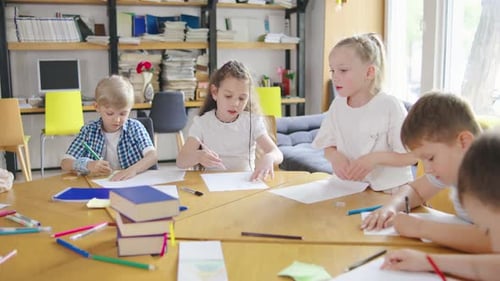 Elementary School Children are Fully Engaged in an Art Class Drawing and Coloring with Pencils and