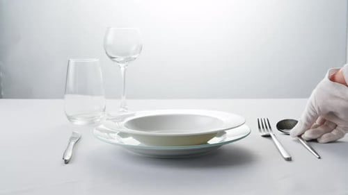 Clean Table Setting with Silverware Being Placed