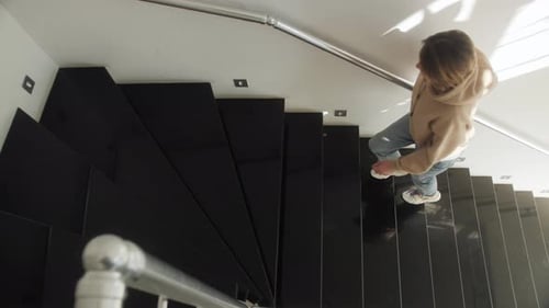 Young Woman Walking Up Stairs Indoors