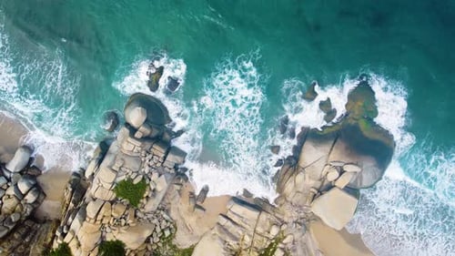Drone view from above blue and white water waves are crashing with big rock at sea of Santa Marta, C