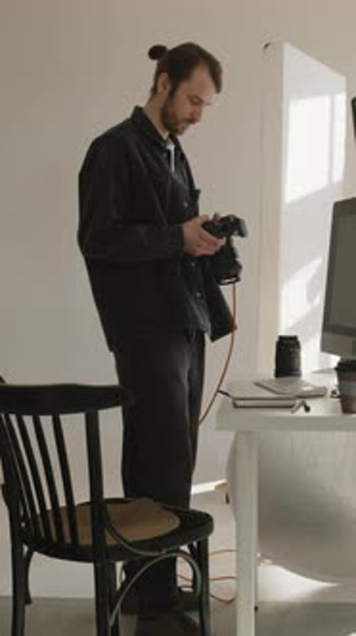 Young Adult Man Holding a Camera Indoors