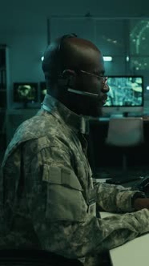 Soldier Working on Computer Wearing Headset in Office