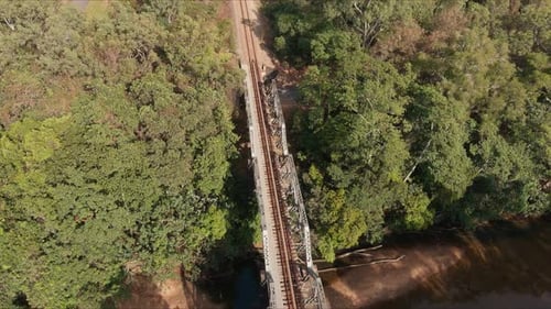 Aerial Shot tracking along a railway bridge over a river