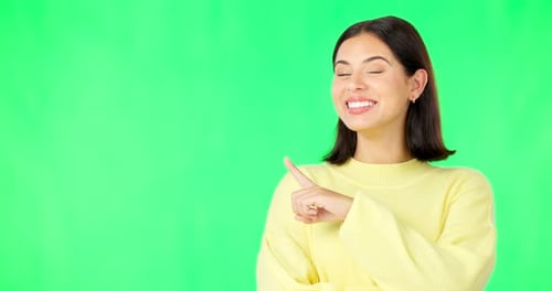 Portrait, pointing and space with a woman on a green screen background in studio for marketing
