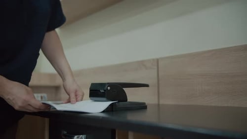 Person using a hole punch in office