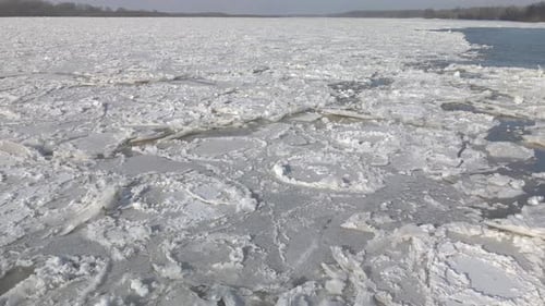 Aerial shot of the great river with floating ice tiles during strong winter in northern Europe