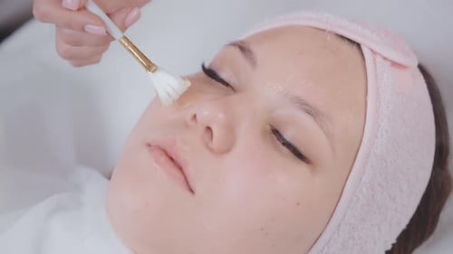 Modern Beauty Treatment in Cosmetology Clinic Aesthetician Applying Mask on Woman Face