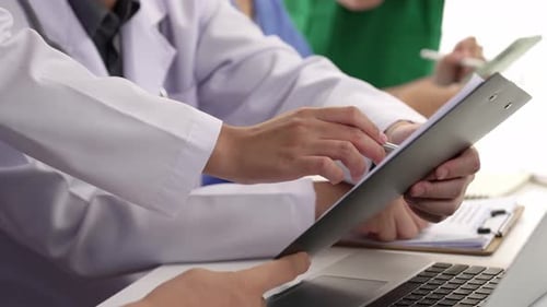 Medical Team Reviewing Patient Chart in Bright Office