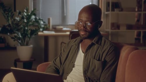 Man Working on Laptop at Home at Night