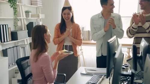 Caucasian businessman and woman celebrating a birthday in the office.